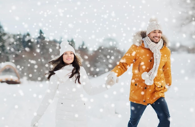 people, season, love and leisure concept - happy couple walking over winter background