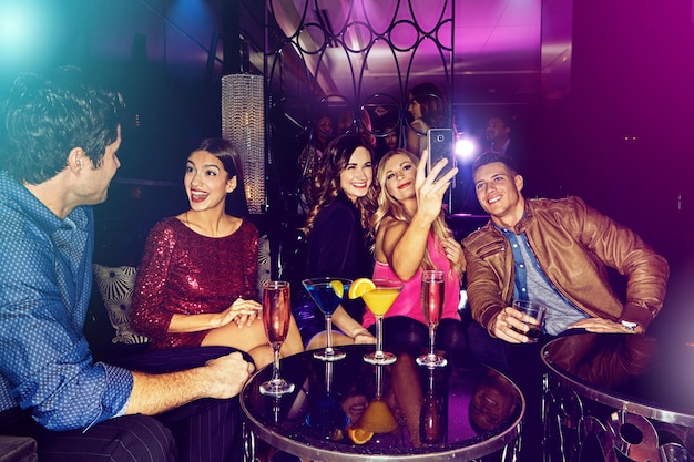 people selfie or friends in nightclub with cocktails smile or drinks for memory vip event or reunion pictures men or happy women on dark party couch for alcohol photograph or social celebration
