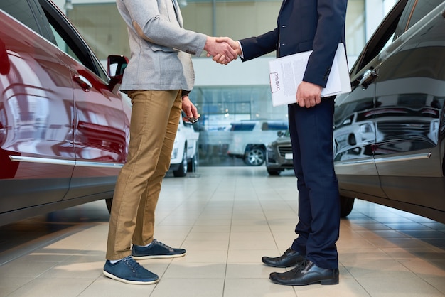 車のショールームで握手する人たち