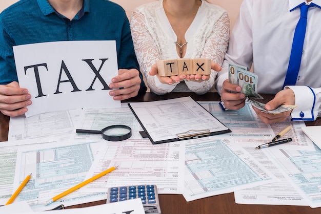 Photo people showing 'tax' word and counting money