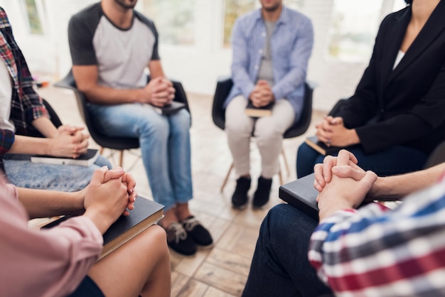 people sit in circle with their hands on their knees