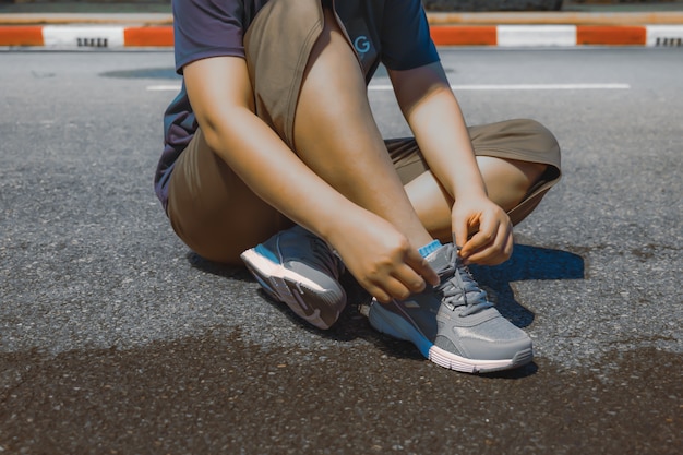 Photo people sit and tie their shoelaces to exercise.