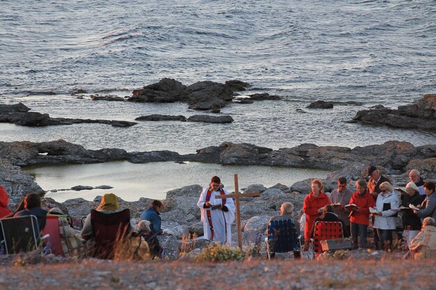 Foto gente seduta sulla spiaggia vicino al mare