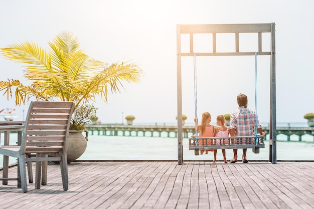 People sitting on bench by chairs against sky