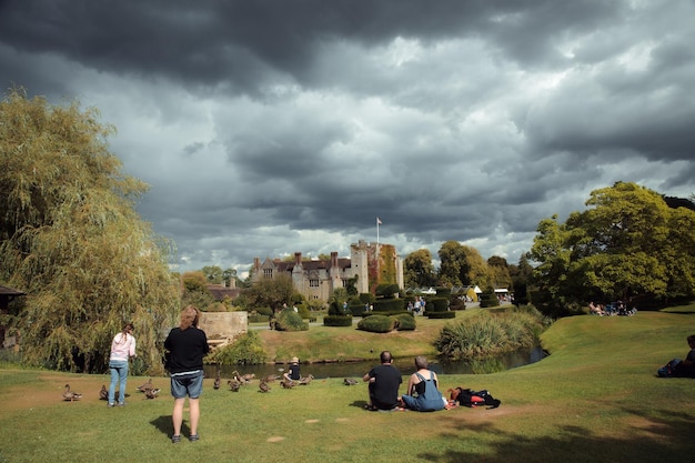 People sitting on the grass in front of a castle