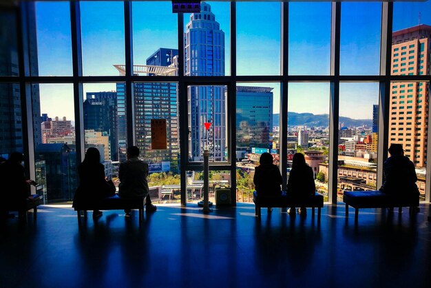 Photo people sitting on sofa in building against sky