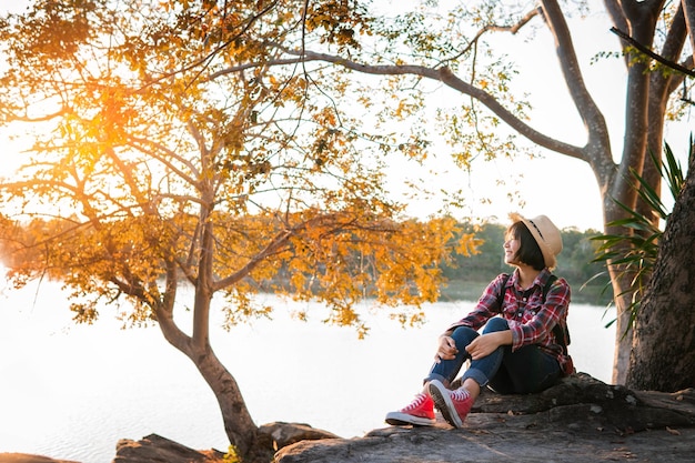 Photo people sitting on tree by autumn leaves