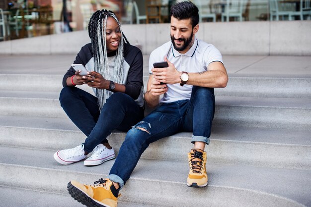 People sitting using smartphone together