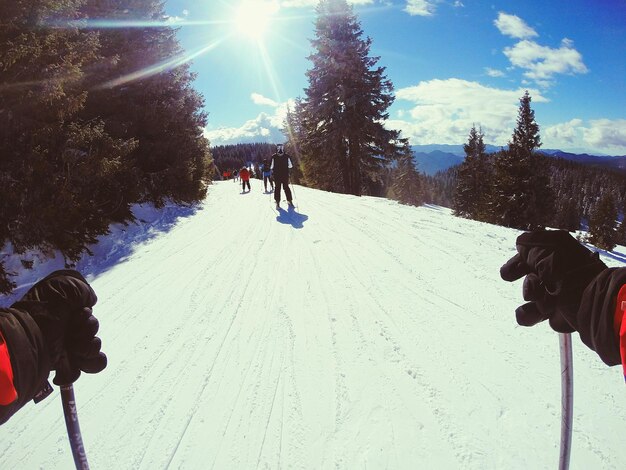 People skiing on snow covered mountains against sky