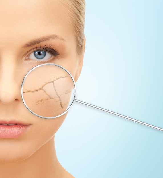 people, skin care and beauty concept - face of beautiful happy young woman over blue background