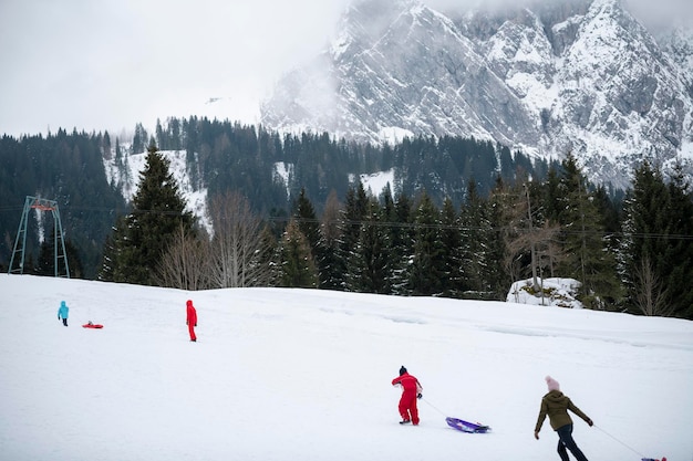 Photo people sledding in the mountains in winter