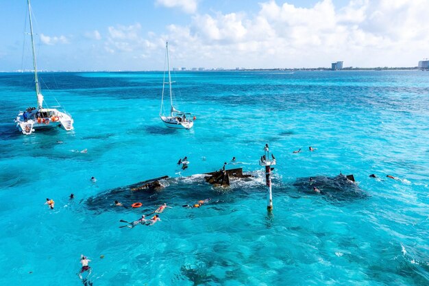 Photo people snorkelling around the ship wreck near bahamas in the caribbean sea
