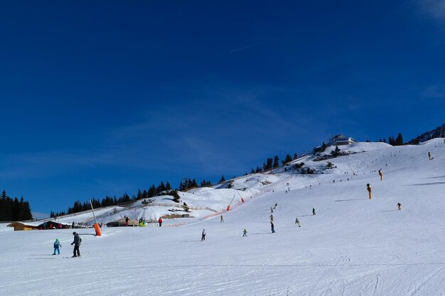 People on snow covered landscape against sky