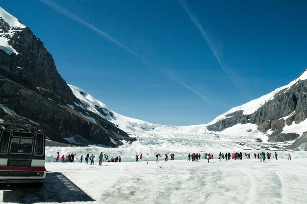 People on snowcapped mountain against sky