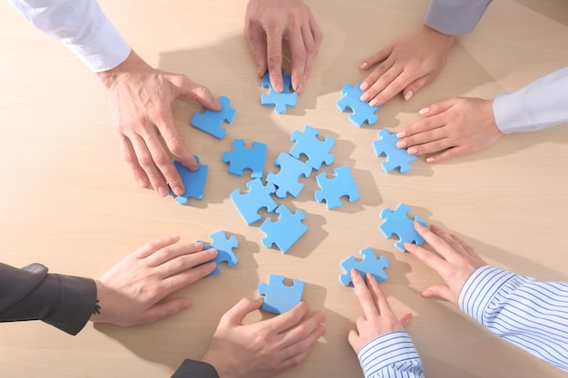 People solving puzzle together on table top view Unity concept