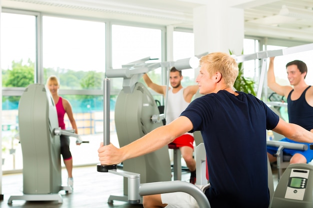 People in sport gym on the fitness machine