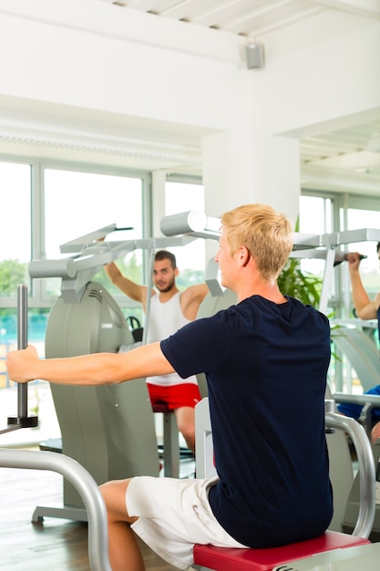 People in sport gym on the fitness machine