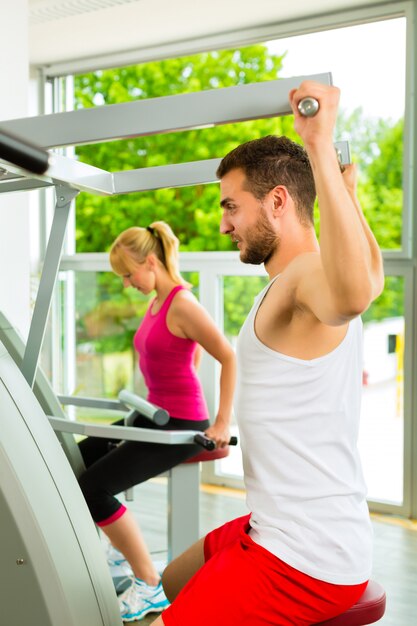 People in sport gym on the fitness machine