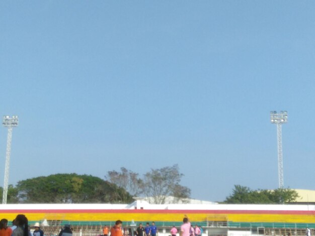 People at stadium against clear sky