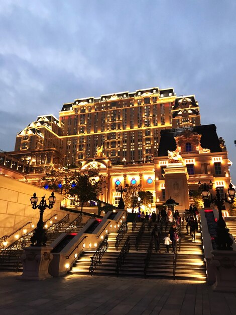 Photo people on staircase of illuminated building in city at dusk