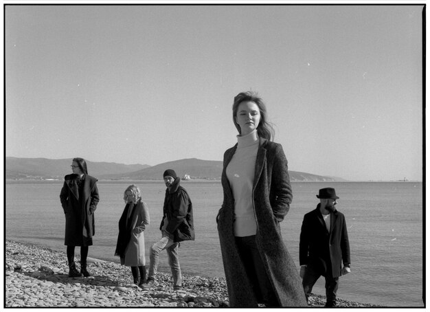 People standing at beach against clear sky