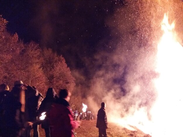 Photo people standing by fire at night