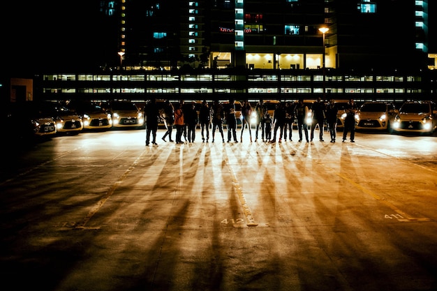 People standing in front of cars at parking lot