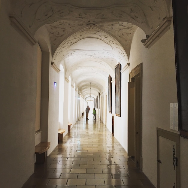 people standing in passage of historic building