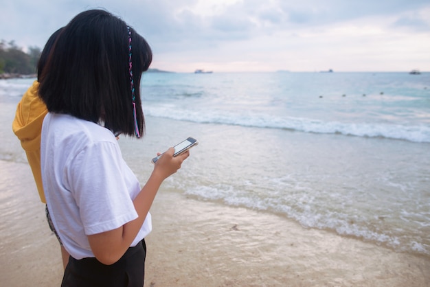 海岸に沿って電話で立っている人。