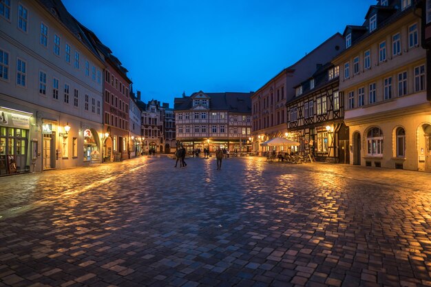 People on street amidst buildings at night