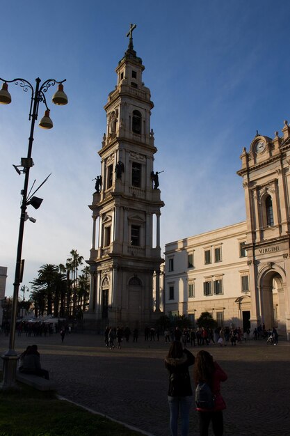 Photo people on street by buildings against sky in city pompei