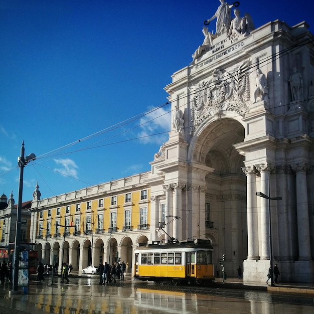 People on street at praca do comercio against sky