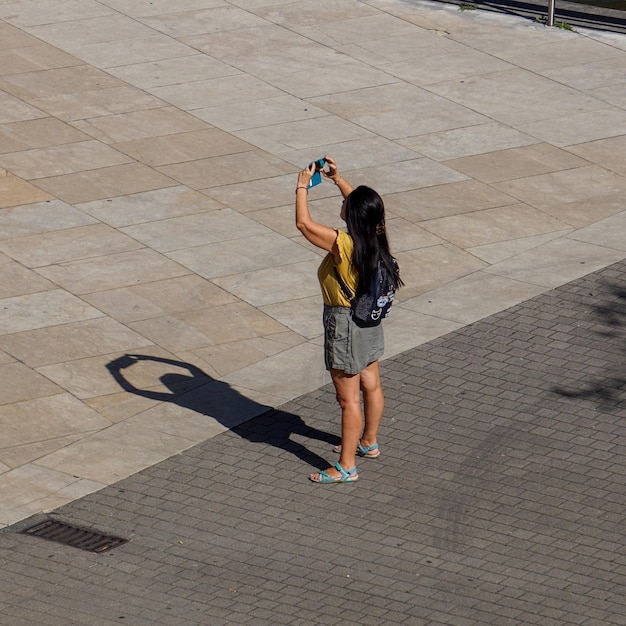 スペインのビルバオ市でストリートでスマートフォンで写真を撮っている人々
