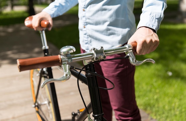 사진 사람, 스타일, 레저 및 라이프스타일 - 도시 거리에서 고정 기어 자전거를 탄 젊은 힙스터 남자 가까이
