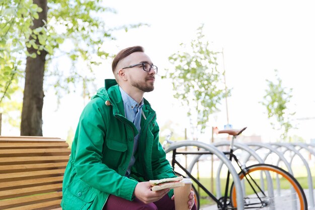 people, style, leisure and lifestyle - happy young hipster man with fixed gear bike on city street