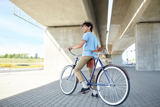 人、スタイル、レジャー、ライフスタイル – 街の通りで固定ギアの自転車に乗る流行に敏感な若者