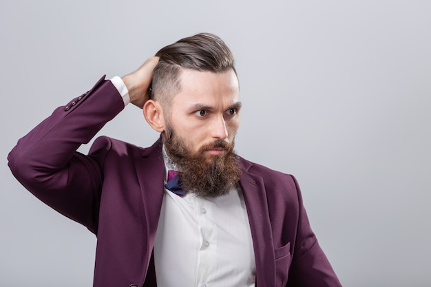 people, stylish and fashion concept - attractive bearded hipster man posing over grey background