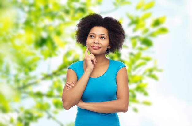 people, summer and eco concept - happy afro american young woman over green natural background