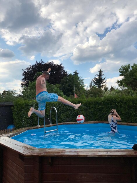 People in swimming pool against sky