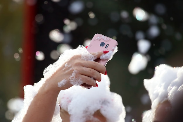 People take pictures of themselves with a mobile phone on a soap disco