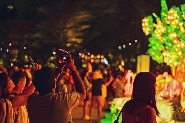 Foto persone che scattano foto ai gardens by the bay di singapore di notte