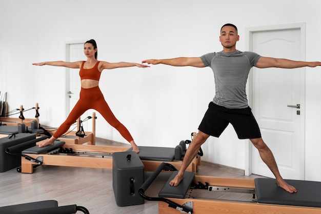 Photo people taking  pilates reformer class