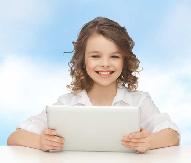 people, technology and children concept - happy smiling girl with tablet pc computer over blue sky background