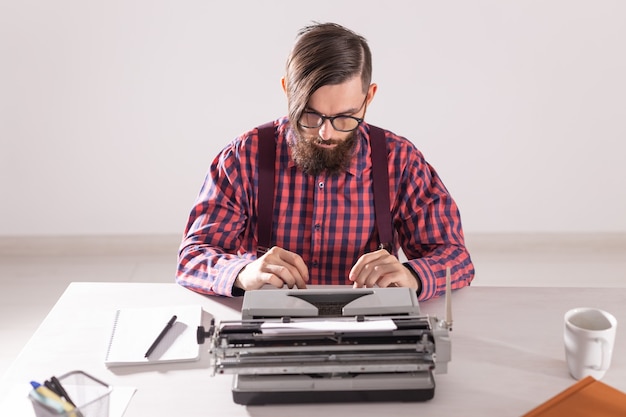Photo people and technology concept - portrait of bearded man in plaid shirt typing over grey wall