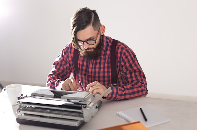 Foto persone e concetto di tecnologia - ritratto di scrittore che lavora alla macchina da scrivere.