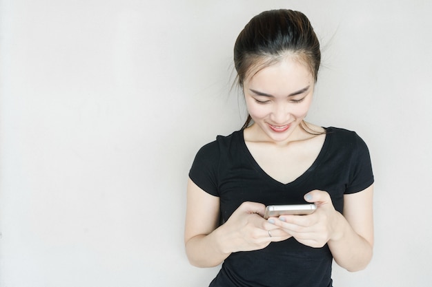 people, technology and internet concept - Beautiful happy Asian woman using smartphone