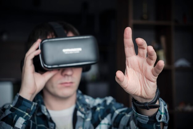 People and technology metaverse concept Young caucasian man using virtual reality glasses at home