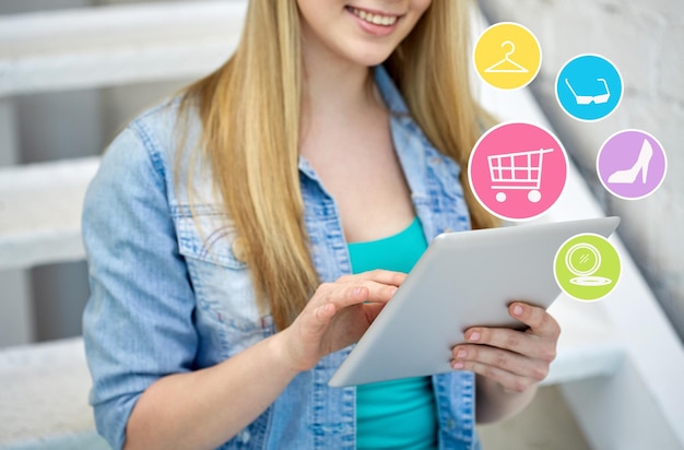 people, technology and online shopping concept - close up of female with tablet pc computer and internet icons on stairs