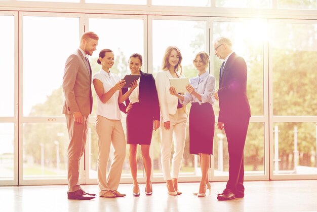 people, technology, work and corporate concept - business team with tablet pc computers at office