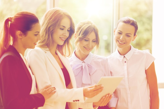 people, technology, work and corporate concept - business team of women with tablet pc computer at office